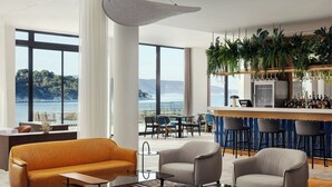 A modern lounge area with a bar, seating, and a view of the sea. - The Isolano, Cres, Autograph Collection (Cres)