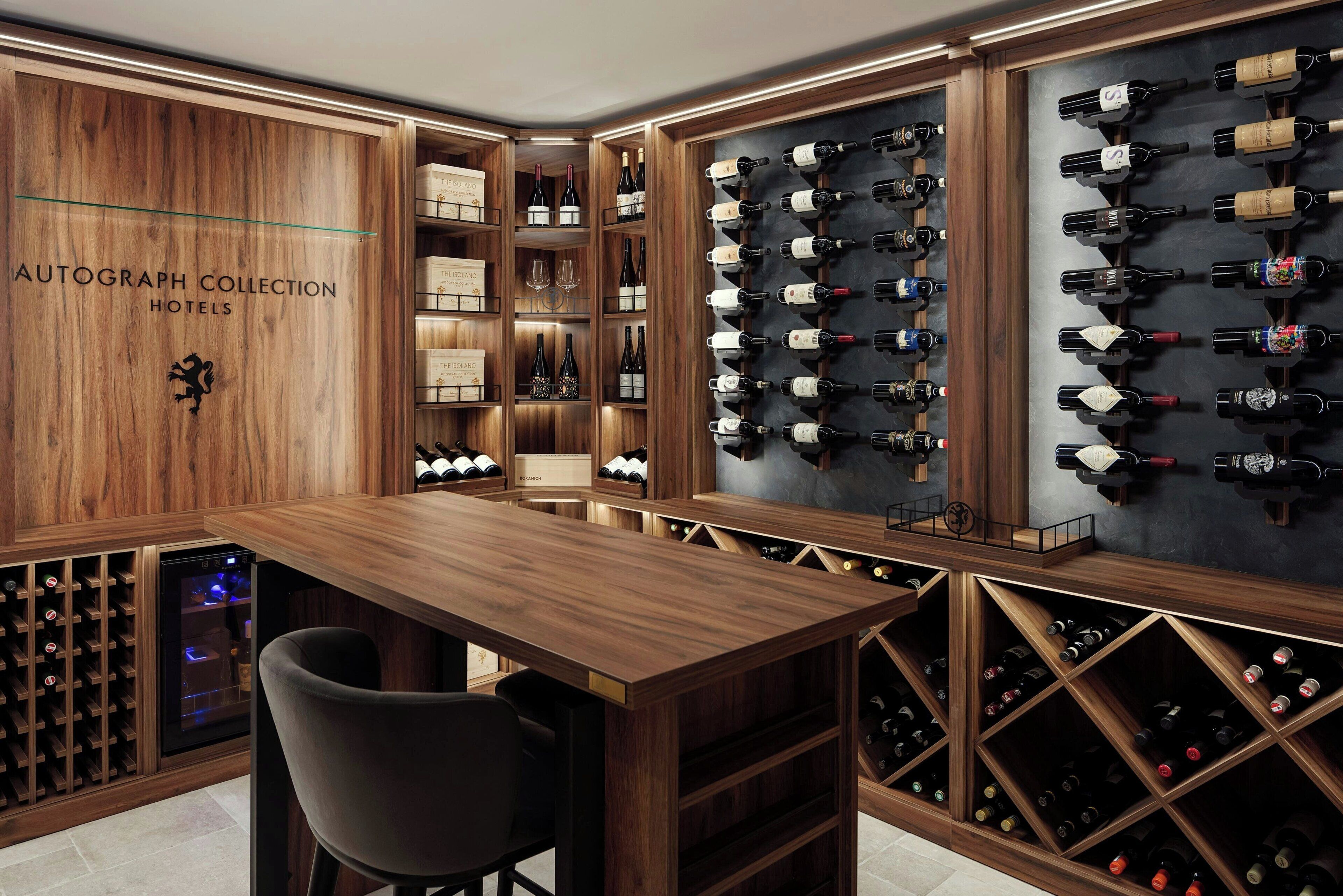 Une cave à vin aux murs en bois, avec un espace bar et de nombreuses étagères à bouteilles.