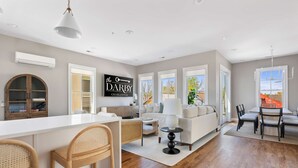 A spacious living area with a large white island, a sofa set, and a dining table with chairs. - 3 Luxury Houses w/ Patios | 1 Block from King St (Charleston)