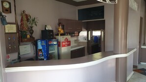 A kitchen with a refrigerator, a clock, and a statue. - Mayon View Garden Apartelle Sa Bukid (Legazpi)