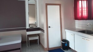 A small kitchenette with a sink, a trash bin, and a door. - Mayon View Garden Apartelle Sa Bukid (Legazpi)