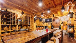 Un interior de madera con una barra larga, estanterías para vino y una puerta de madera.