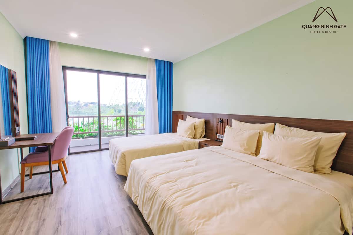 Une chambre d’hôtel avec deux lits, un bureau et une chaise.