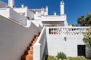 A white building with a staircase leading to a terrace.