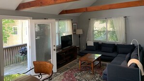 A living room with a sofa, TV, and a ceiling fan.