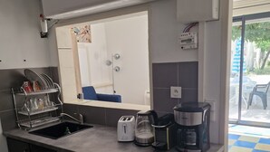 Una cocina compacta con lavavajillas, horno y cafetera en la encimera.