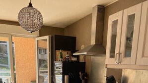 A modern kitchen with a built-in oven, stainless steel cabinets, and a pendant light. - SEVRIER, Bel appartement de 73M2 de 2 chambres pour 4 personnes avec parking et terrasse avec vue sur les montagnes, situé à 500m de la piste cyclable et du lac... (Sévrier)
