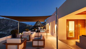 A modern outdoor seating area with a view of a mountainous landscape.