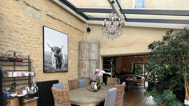 A cozy dining area with a wooden table, wicker chairs, and a chandelier. - Hidden gem in Bayeux : 3 bedrooms, backyard and spa -  king and queen size beds (Bayeux)
