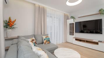 Apartment, 1 Bedroom, Balcony | Living room | 65-inch flat-screen TV with cable channels