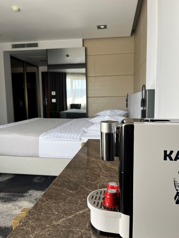 Habitación de hotel con cama, un minibar y un baño a la vista.
