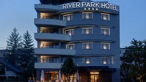 A multi-story hotel with a modern design, featuring balconies and a prominent sign reading "RIVER PARK HOTEL". - River Park Hotel (Cluj-Napoca)