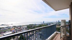Un balcón con vista a un paisaje urbano costero, que incluye edificios y una masa de agua.