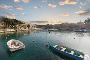 Un port avec des bateaux, un fort et des bâtiments le long de la rive.