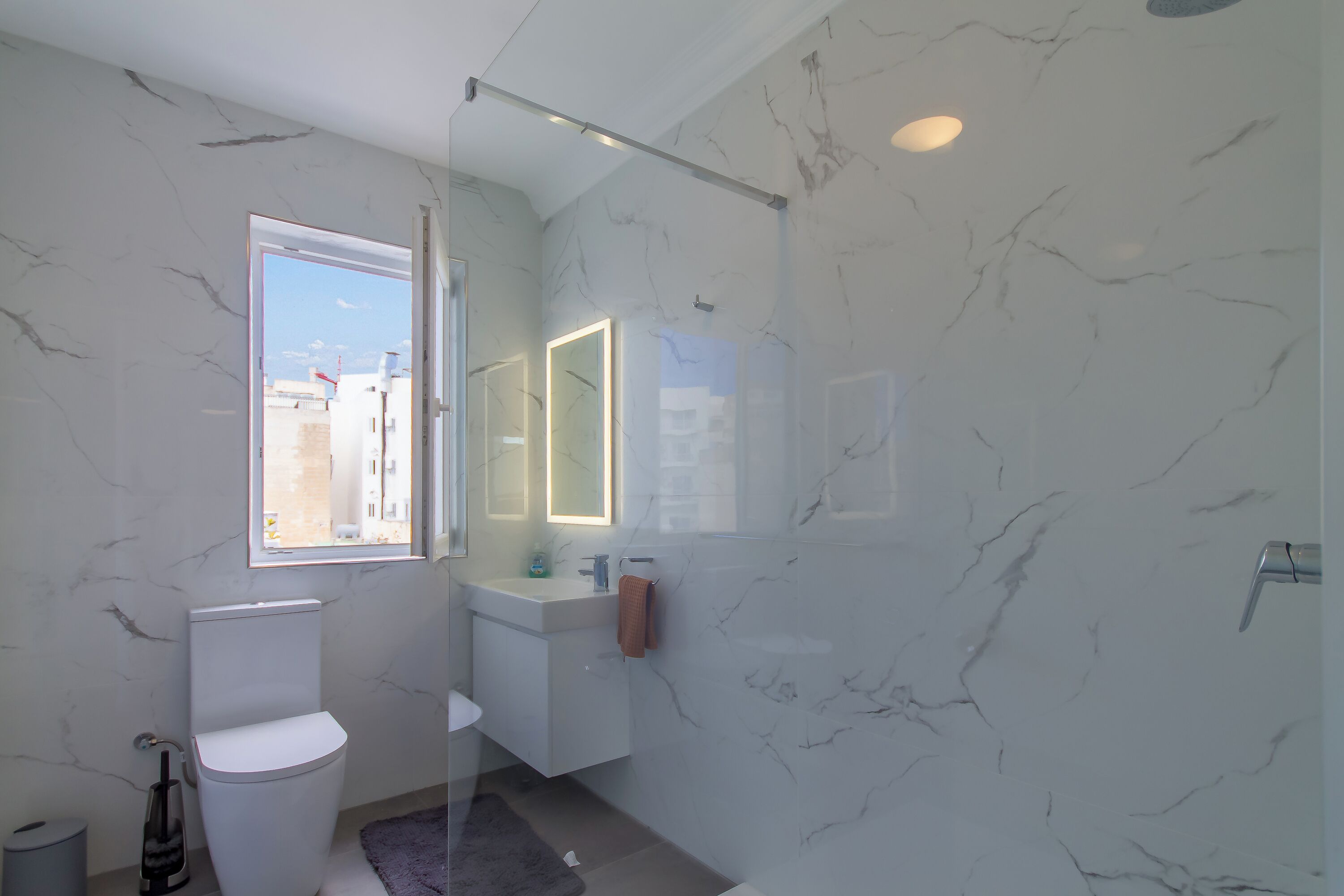 A modern bathroom with a toilet, sink, and shower.