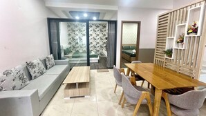 Una sala de estar moderna con un sofá, una mesa de comedor de madera y sillas.