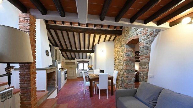 Ein gemütliches Interieur mit einer Steinwand, einem Essbereich und einer Couch.