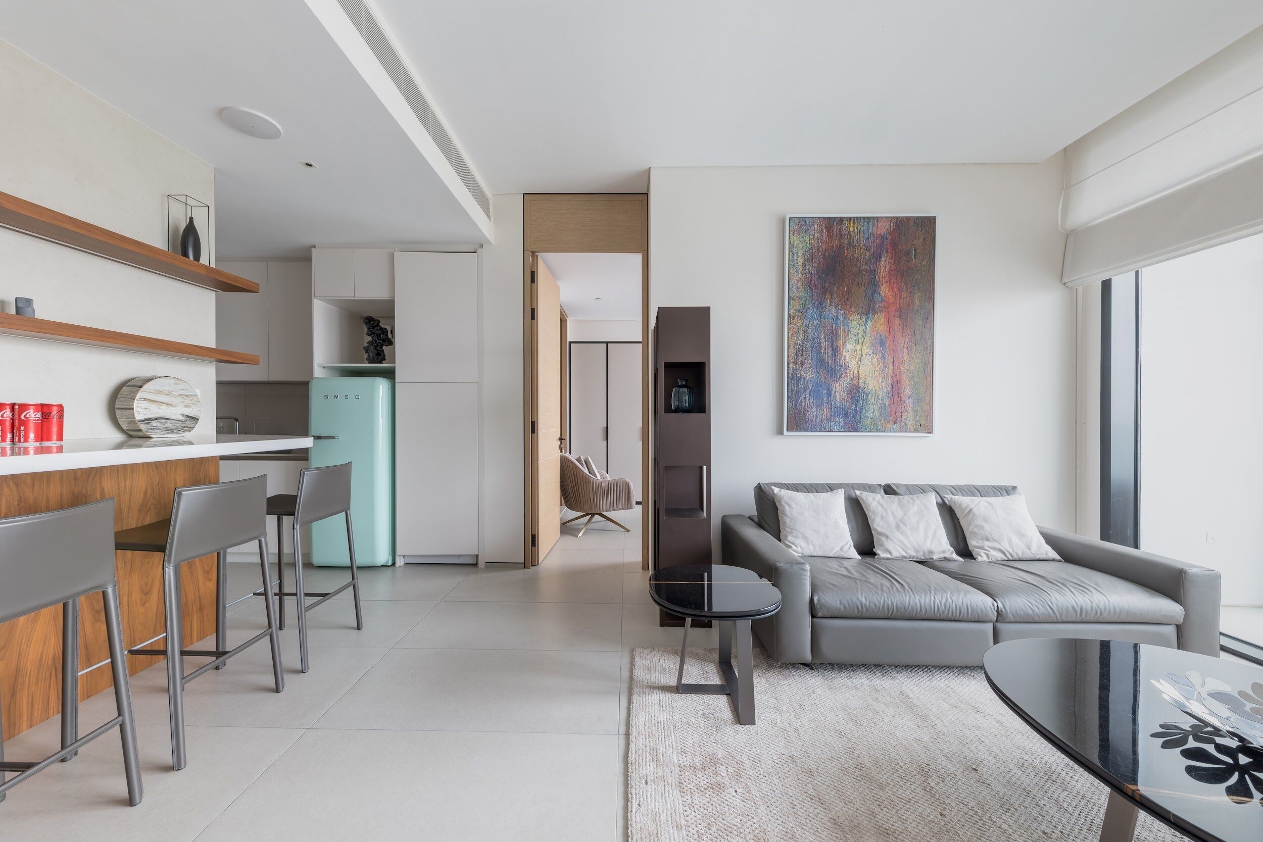 A modern living space with a kitchen, dining area, and seating area.