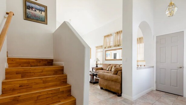 Eine Treppe führt zu einem Wohnbereich mit einer Couch und einer Tür.