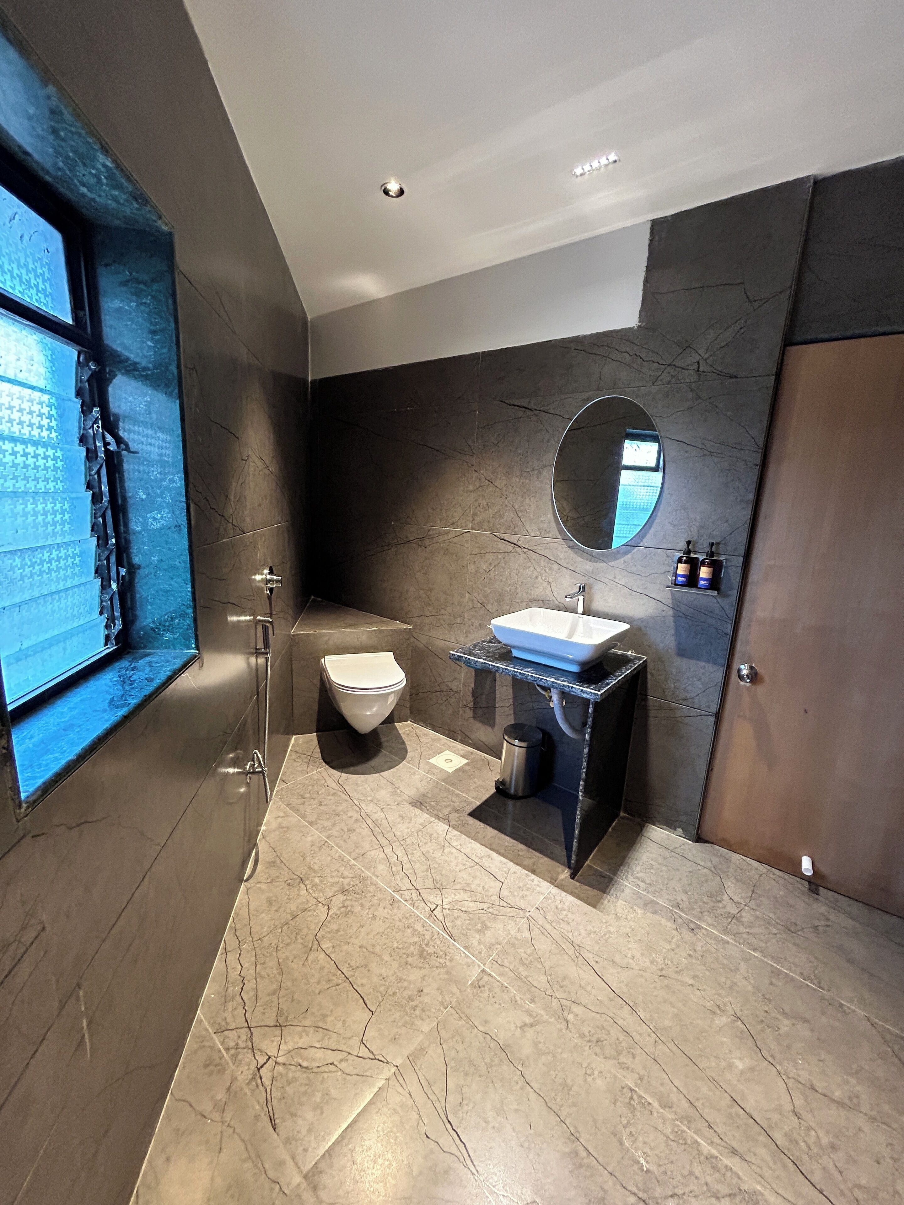 A modern bathroom with a toilet, sink, and mirror.