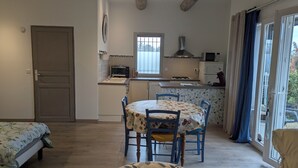 A compact kitchen with a dining table, chairs, a microwave, and a refrigerator. - Cottage in Provence Luberon with swimming pool (Cabrières-d'Avignon)