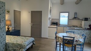 A compact kitchen with a microwave, toaster, and sink. There is a dining area with a table and chairs. - Cottage in Provence Luberon with swimming pool (Cabrières-d'Avignon)