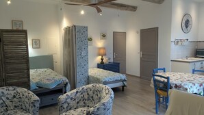 A room with two beds, a desk, a chair, a lamp, a clock, and a small kitchenette. - Cottage in Provence Luberon with swimming pool (Cabrières-d'Avignon)