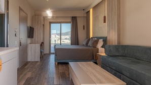 Une chambre d’hôtel moderne équipée d’un lit, d’un canapé, d’une télévision et offrant une vue sur la ville.