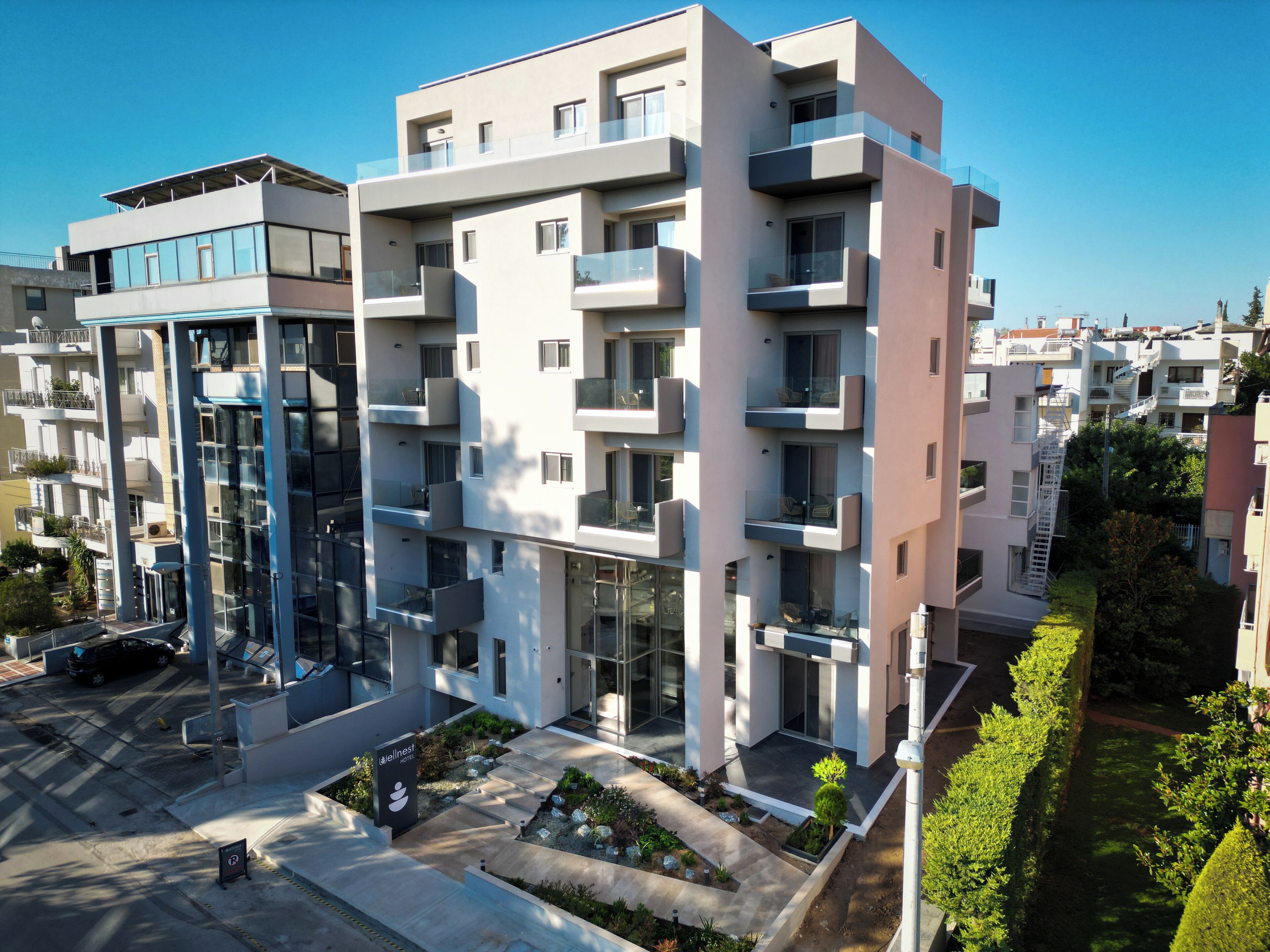 Un hôtel moderne à plusieurs étages, doté de balcons, d’un parking et d’un jardin bien entretenu.