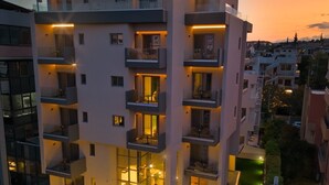Un immeuble moderne à plusieurs étages, doté de balcons, d’une cour aménagée et offrant une vue sur le quartier environnant.