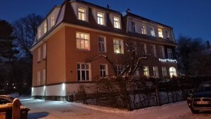 A multi-story hotel with a classic architectural design, featuring multiple windows and a well-lit facade. - 120m², 6+1 Pers. 3 SZ / 4TV 100 Mbit/s +netflix (Arnsdorf)