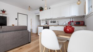 A modern kitchen with white cabinets, a wooden countertop, and a red pot. - Italianway - Piranesi 18 B int C345 - City View (Milan)