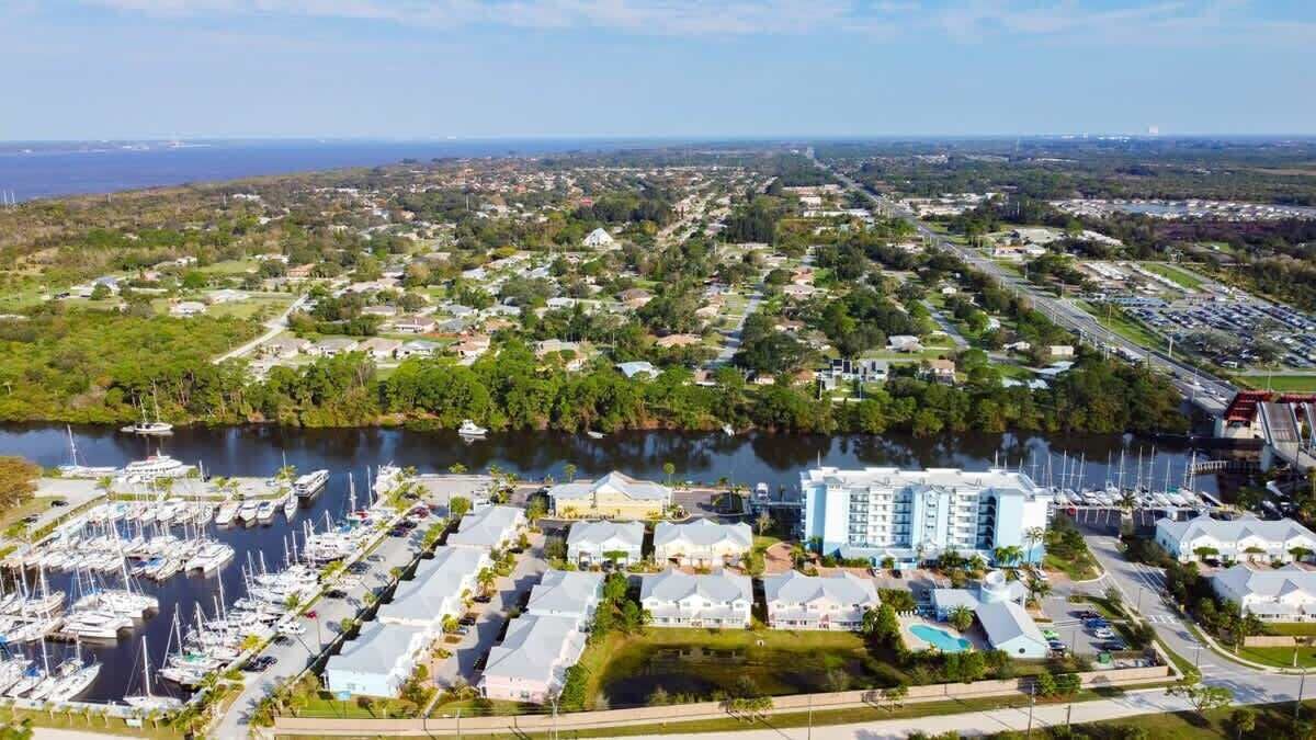 A marina with numerous boats, a residential area with single-story houses, and a large hotel with multiple floors.