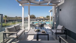 A modern outdoor patio with a pool, seating, and a clear view of the landscape. - Pura Vida Villa, 2 Heated Pools, Hot Tubs & Sauna (Rethymno)