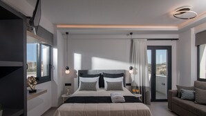 A modern bedroom with a large bed, a sofa, and a balcony. - Pura Vida Villa, 2 Heated Pools, Hot Tubs & Sauna (Rethymno)