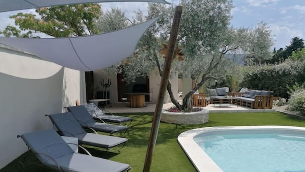 Ein Poolbereich mit Liegestühlen, einem kleinen Pool und einem schattigen Platz.