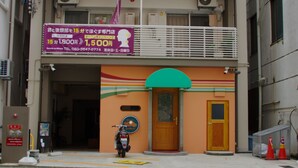 A building with a sign advertising a 15-minute haircut and a 1,500 yen discount. - Island Stay Izumizaki Hotel (Naha)