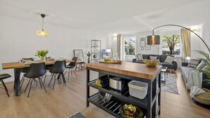 Ein modernes Wohnzimmer mit Essbereich, einer Sofagarnitur und einer Kücheninsel.