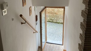 Un escalier menant à une porte dont le mur extérieur est en pierre.