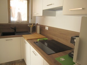 Eine Küche mit Spüle, Holz Arbeitsplatte und Schränken.