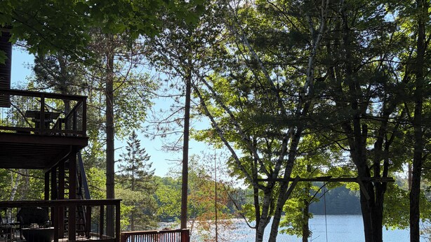 A lakeside deck with outdoor seating and a view of the lake. - Discover Serenity: Ultimate Summer Getaway Awaits at Charming Cottage Retreat! (Bancroft)
