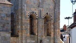 Un edificio histórico de piedra con ventanas de arco y una entrada central.