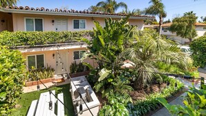 A residential property with a patio, outdoor lighting, and lush greenery.