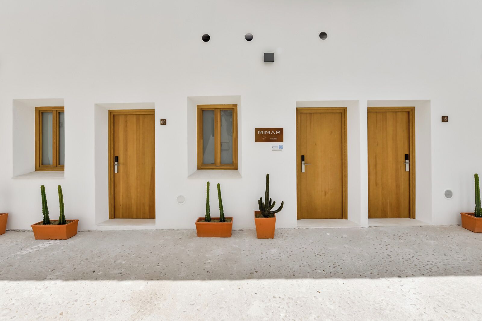Una fila de puertas de madera con un letrero sobre la tercera puerta que dice "MIMAR".