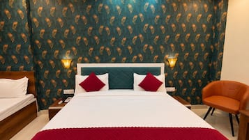 Una habitación de hotel con una cama grande, dos mesitas de noche, una silla y un papel tapiz estampado.