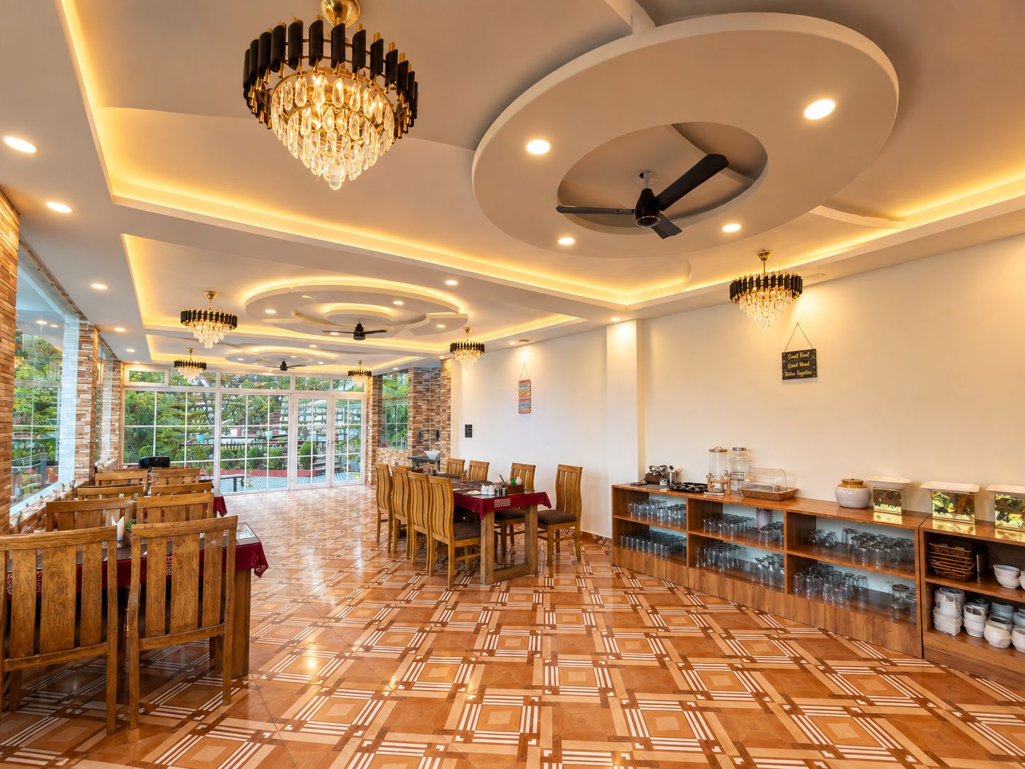 A spacious dining area with wooden furniture, a patterned floor, and ceiling fans.