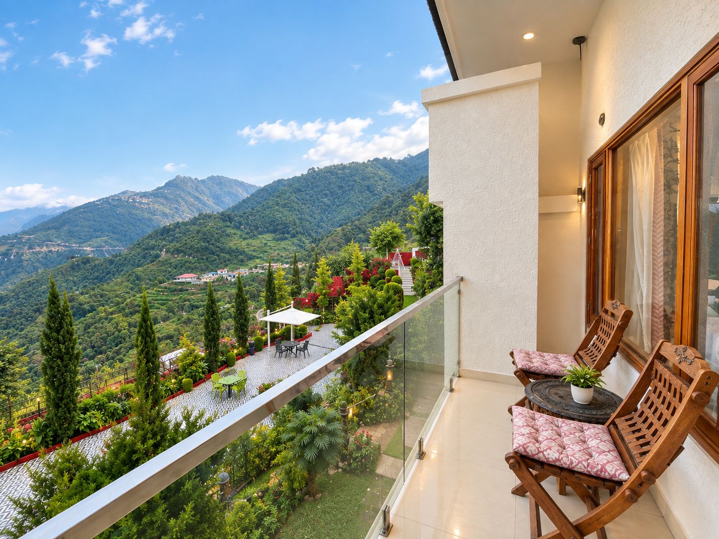 Un balcon donnant sur un paysage montagneux, une chaise en bois et une petite table.
