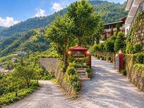 A gravel path leading to a villa entrance with a sign reading 'Welcome to Luxmi Villas Inn.' - Hotel Luxmi Vilas Inn (Dhanaulti)
