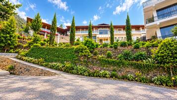 Un hotel con jardín ajardinado, varias construcciones y cielo despejado.