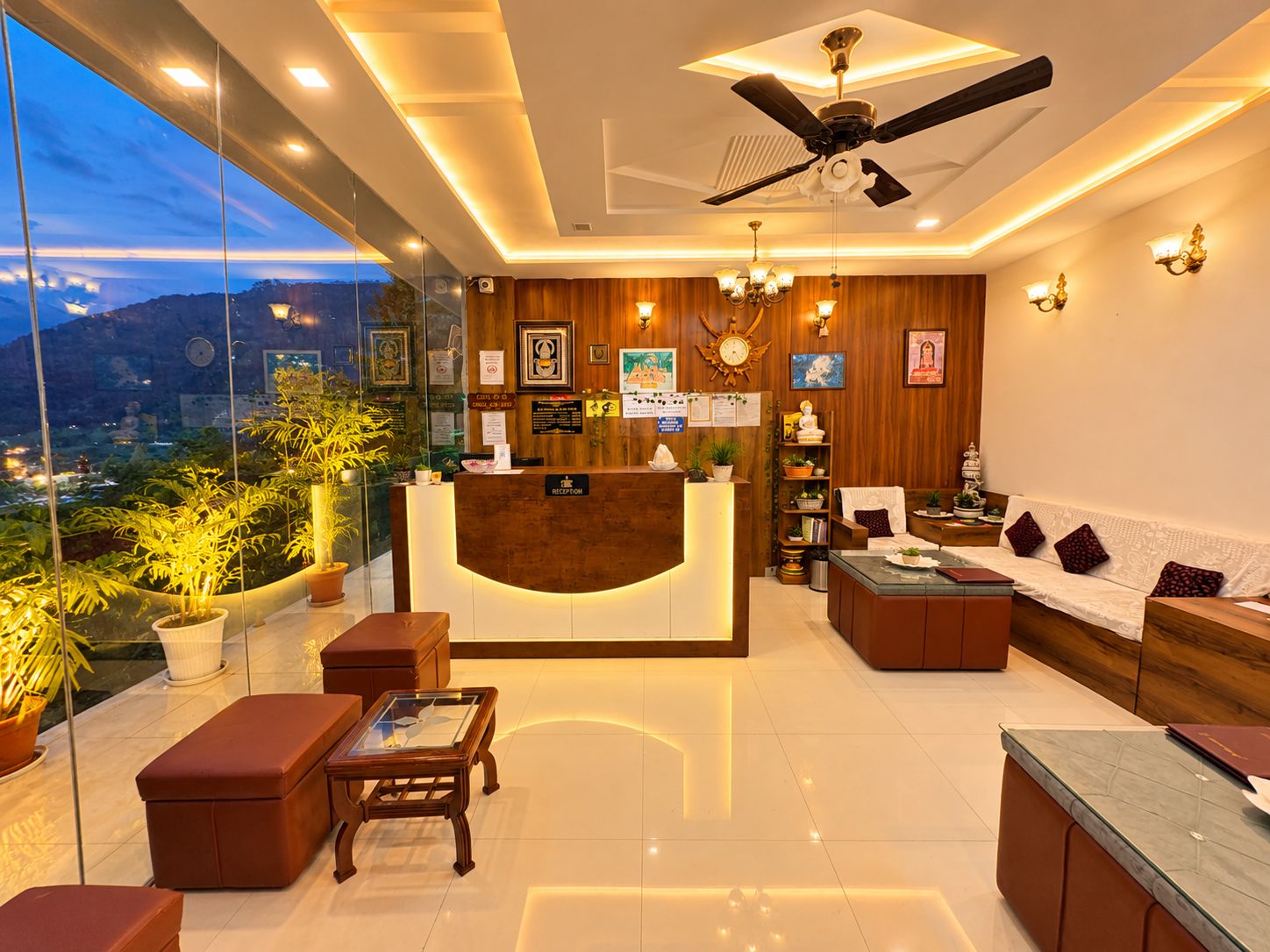 A hotel reception area with a reception desk, seating, and a view of the cityscape.